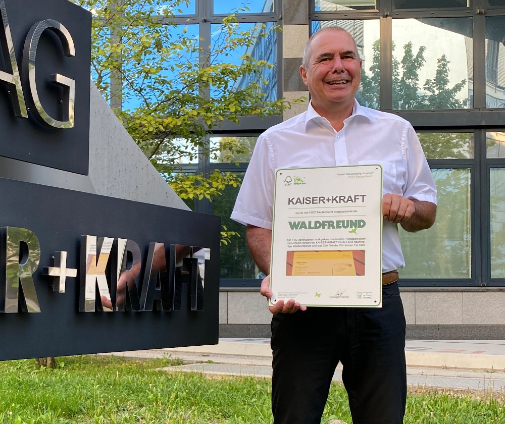 Lutz Frey, Abteilungsleiter Produktmanagement bei Kaiser+Kraft, präsentiert die FSC-Auszeichnung „Waldfreund“. Abbildung: Kaiser+Kraft 