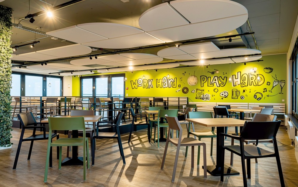 Das effektvolle Zusammenspiel zwischen Deckenbild, Mobiliar und Raumgestaltung erweckt die Cafeteria zum Leben. Abbildung: Matthias Engler, Akquinet