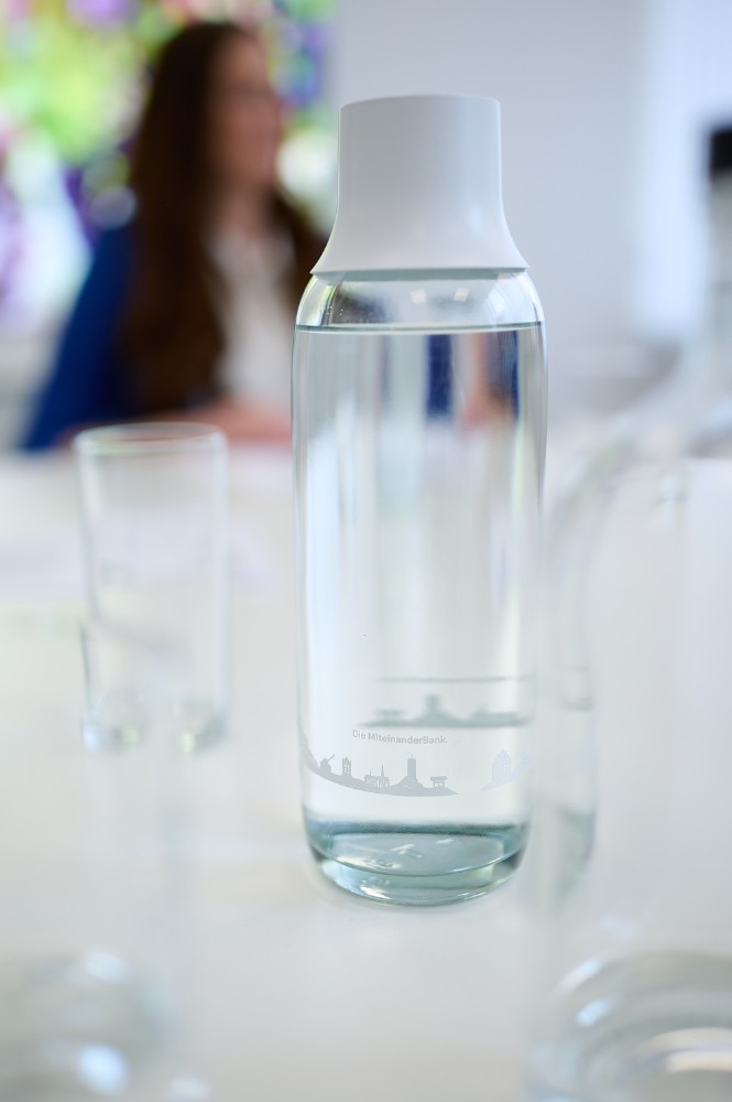 Jeder Mitarbeitende der „MiteinanderBank“ erhält zwei gebrandete Glasflaschen, wodurch die Corporate Identity gestärkt wird. Abbildung: Andreas Huber, Copyright: Brita