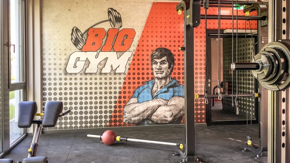 Big Jim trifft Big Gym: Fitnessstudio, benannt nach der Kult-Actionfigur von 1970. Für sportliche Erholung. Abbildung: Goldbeck GmbH